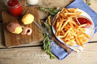 Ahşap masa arka plan üzerinde plaka üzerinde lezzetli Fransız kızartması