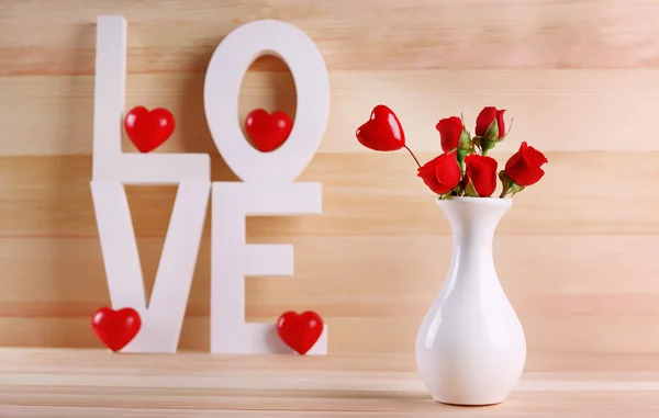 Letras decorativas formando palavra AMOR com flores sobre fundo de madeira — Fotografia de Stock