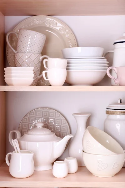 Kuchyňské potřeby a nádobí na dřevěných policích — Stock fotografie