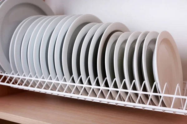 Plaques propres séchage sur porte-plats en métal sur étagère — Photo