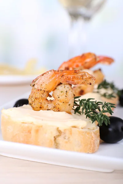 Vorspeise Canape mit Garnelen und Oliven auf dem Tisch auf hellem Hintergrund — Stockfoto