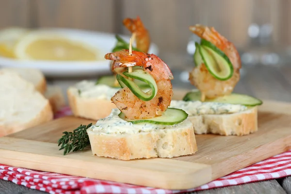 Appetizer canapé com camarão e pepino na mesa de perto — Fotografia de Stock