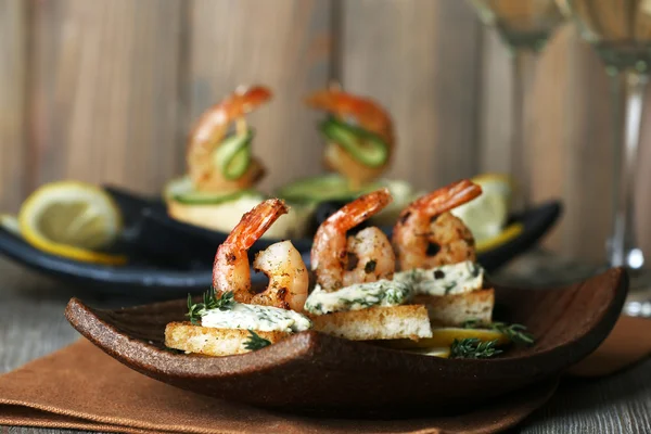 Appetizer canape with shrimp and lemon on plate on table close up — Stock Photo, Image