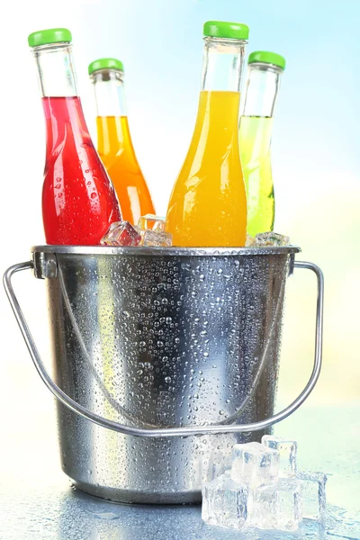 Bottles of drink in metal bucket with ice