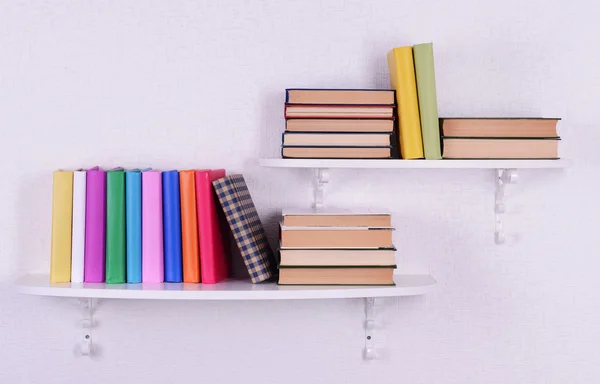 Books on shelves on white wall background — Stock Photo, Image