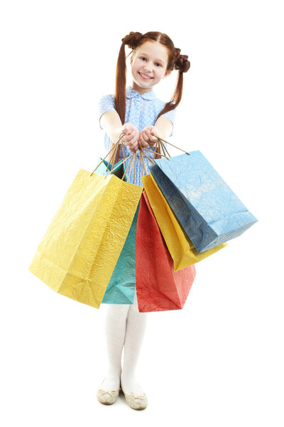 Beautiful little girl with shopping bags, isolated on white