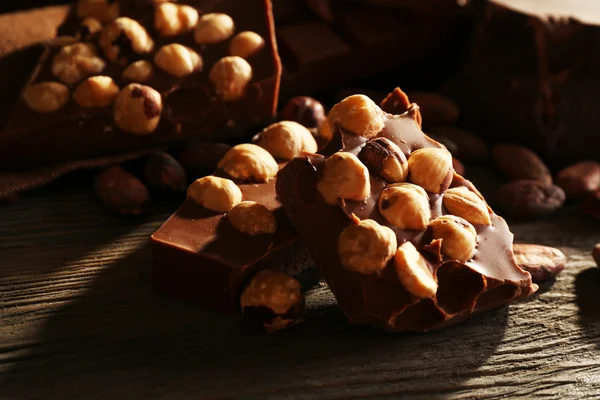 Νεκρή φύση με το σύνολο της σοκολάτας με ξηρούς καρπούς στο ξύλινο τραπέζι, κινηματογράφηση σε πρώτο πλάνο — Φωτογραφία Αρχείου
