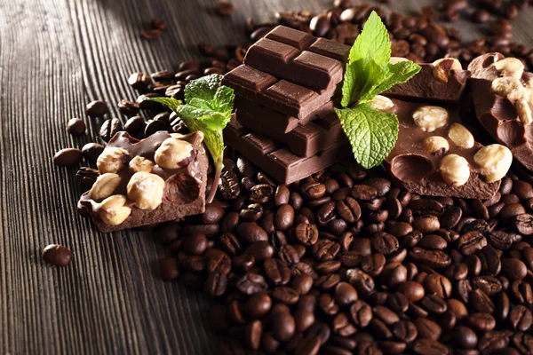 Chocolate with mint and coffee beans on wooden table, closeup — Stock Photo, Image