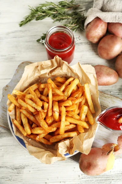 Smakelijke Franse frietjes op snijplank — Stockfoto