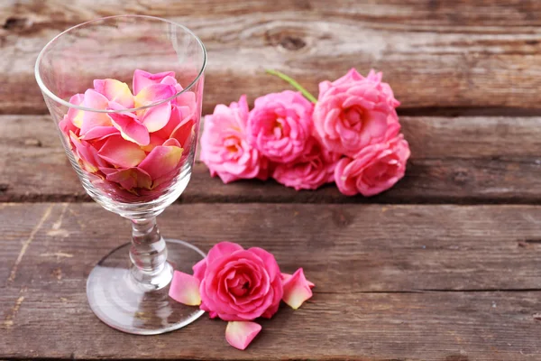 Beautiful pink rose in glass on wooden background — Stock Photo, Image