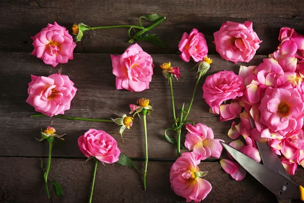 Mooie roze rozen op houten tafel, bovenaanzicht — Stockfoto