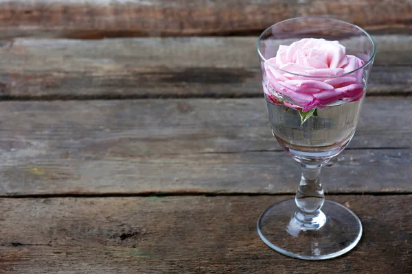 木製の背景にガラスの美しい新鮮なバラ — ストック写真
