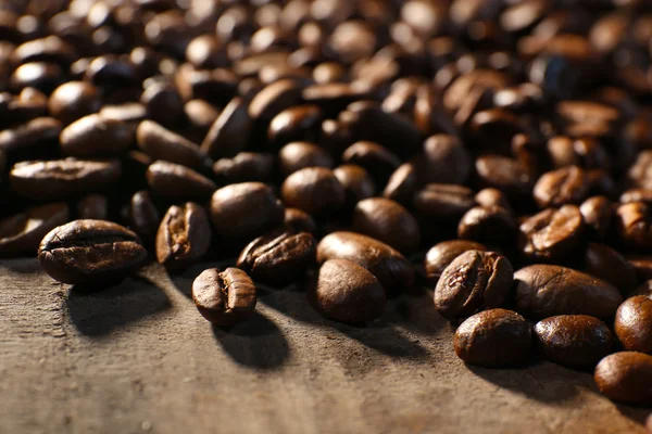 Högen av kaffebönor på träbord, närbild — Stockfoto