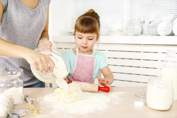 Kleines Mädchen bereitet mit Mutter zu Hause Kekse in Küche zu — Stockfoto