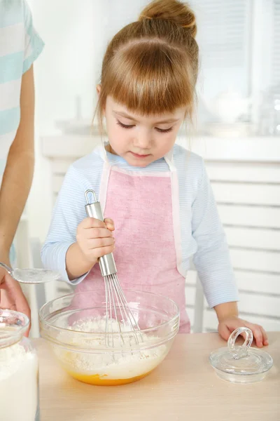 Kis lány készül a cookie-k, anya otthon a konyhában — Stock Fotó
