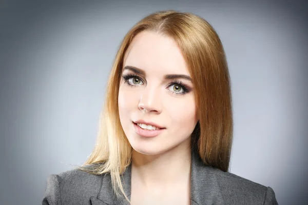 Retrato de una hermosa joven sobre fondo gris — Foto de Stock