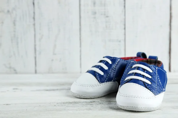 Zapatos coloridos para niños pequeños sobre fondo de madera — Foto de Stock