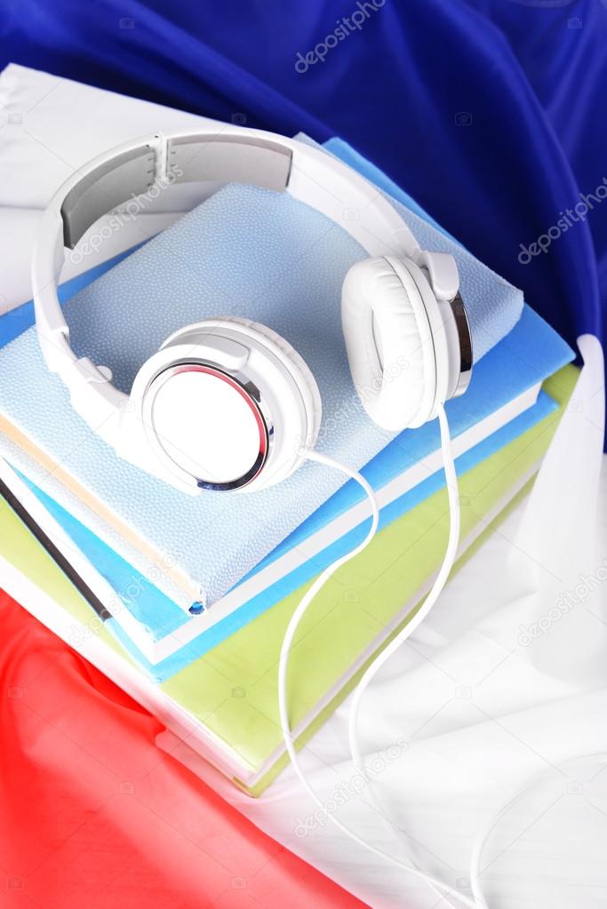 Books and headphones on French flag background