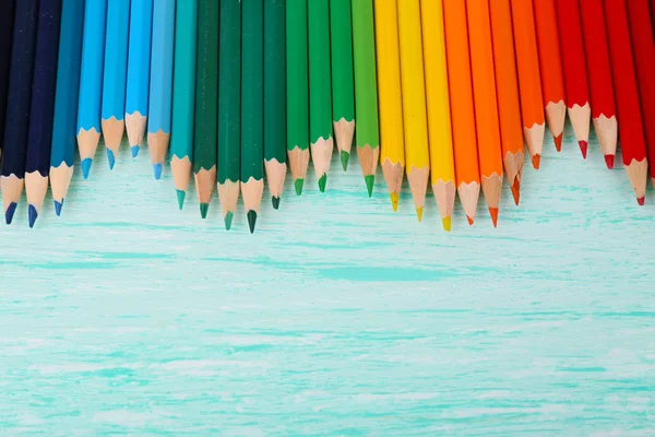 Kolorowe ołówki na drewnianym stole — Zdjęcie stockowe
