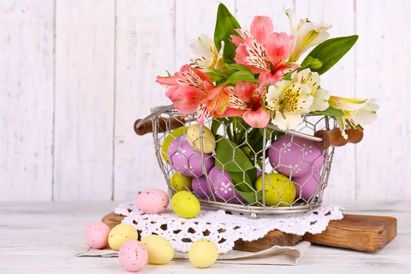 Pasen eieren in een mand en bloemen — Stockfoto