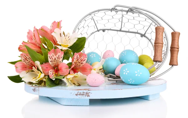 Pasen eieren in een mand en bloemen — Stockfoto