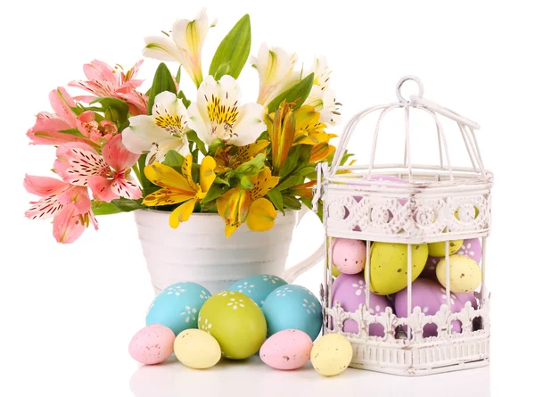 Paaseieren in decoratieve cage en bloemen — Stockfoto