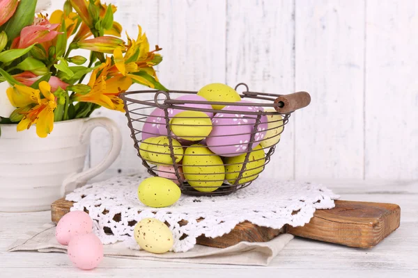 Œufs de Pâques dans le panier et fleurs — Photo