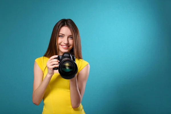 Jovem fotógrafa tirar fotos no fundo azul — Fotografia de Stock