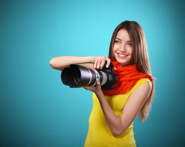 Jeune photographe féminine prenant des photos sur fond bleu — Photo