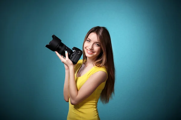 Joven fotógrafa tomando fotos sobre fondo azul —  Fotos de Stock