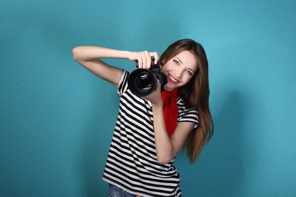 Junge Fotografin fotografiert auf blauem Hintergrund — Stockfoto