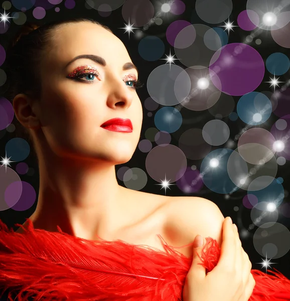 Beautiful woman with  red feather on bright background — Stock Photo, Image