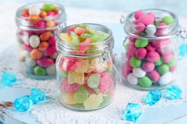 Cam Kavanoz renk ahşap arka plan üzerinde çok renkli şekerler