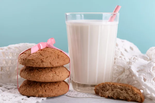 Tasty cookies and glass of milk on color wooden table, on bright background — Stock Photo, Image