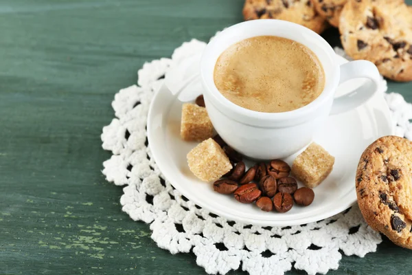 Kopp kaffe och läckra cookie på färg trä bakgrund — Stockfoto