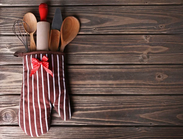 Conjunto de utensílios de cozinha em mitene em pranchas de madeira fundo — Fotografia de Stock