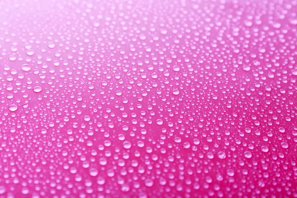 Gotas de água em vidro no fundo rosa — Fotografia de Stock