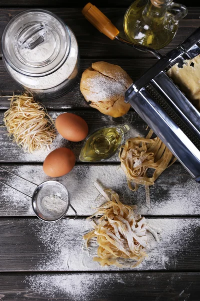 Macchina per pasta metallica e ingredienti per pasta su fondo di legno — Foto Stock