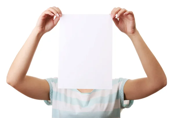 Kağıt üzerinde beyaz izole boş levha ile yüzünü kaplayan kadın — Stok fotoğraf