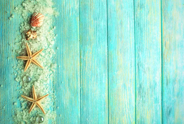 Sea stars on sea salt on wooden background — Stock Photo, Image