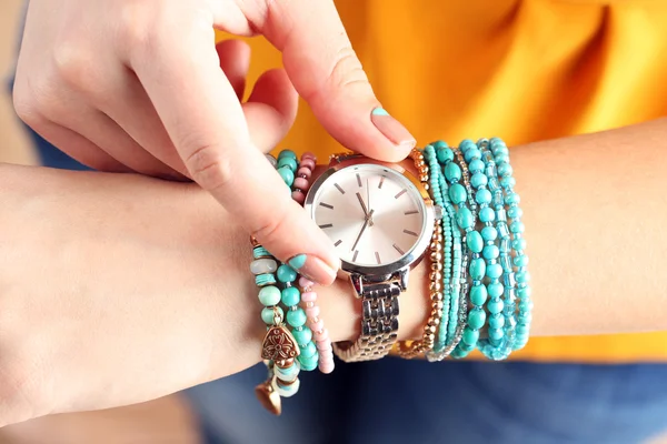 Stylish bracelets and clock on female hand top view — Stock Photo, Image