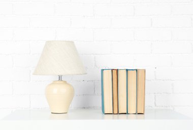 Kitap ve tuğla duvar arka lamba ile ahşap raf