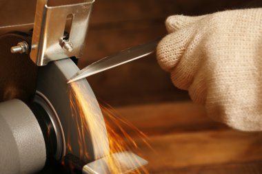 Bıçak Bileyici ve ahşap masa, closeup üzerinde bıçak el