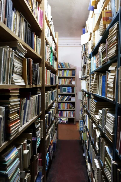 Många böcker om bokhyllan i biblioteket — Stockfoto