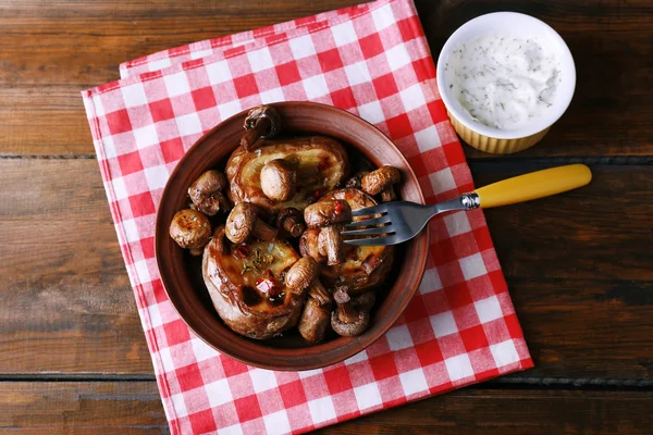 Ofenkartoffeln mit Pilzen in Schüssel und Sauce auf dem Tisch aus nächster Nähe — Stockfoto