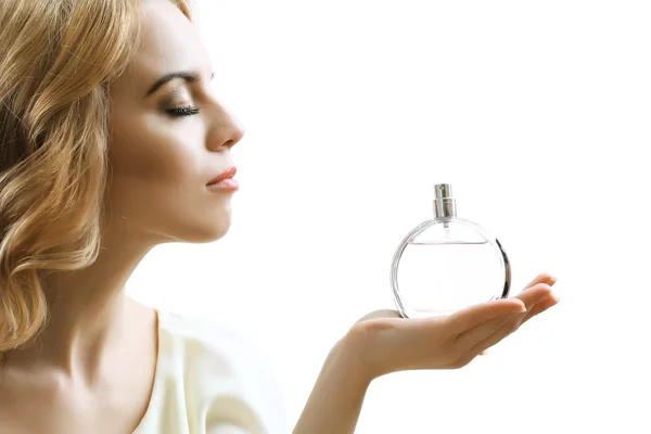 Hermosa joven con botella de perfume aislado en blanco — Foto de Stock