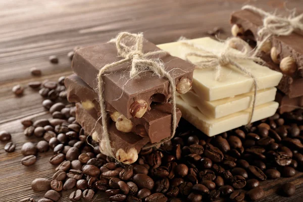 Stack of tied chocolate with coffee beans on wooden table, closeup — Stock Photo, Image