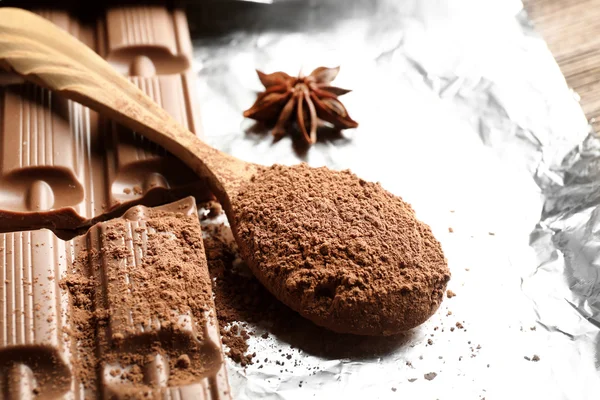 Bar of chocolate with cocoa and star anise on foil, closeup — Stock Photo, Image