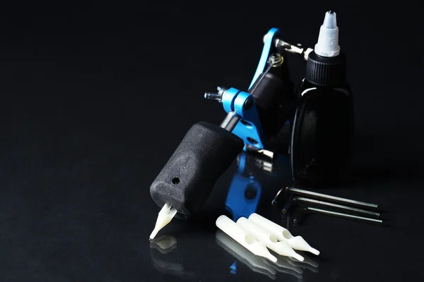 Tattoo machine and tattoo Supplies, on dark background — Stock Photo, Image