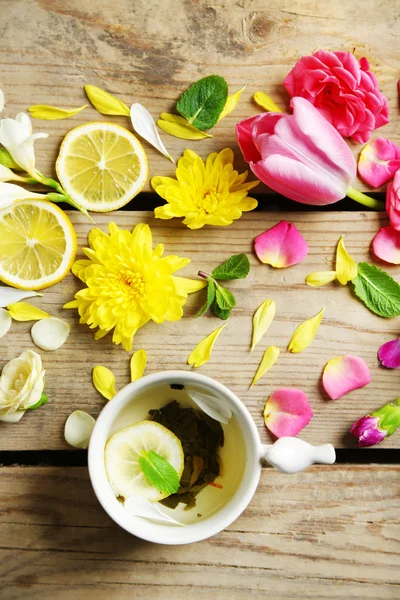 Ahşap zemin üzerine güzel çiçekler ile bitkisel çay — Stok fotoğraf
